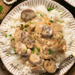 Mushroom chicken served over white rice with a fork.