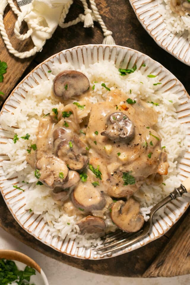 Mushroom chicken served over white rice with a fork.
