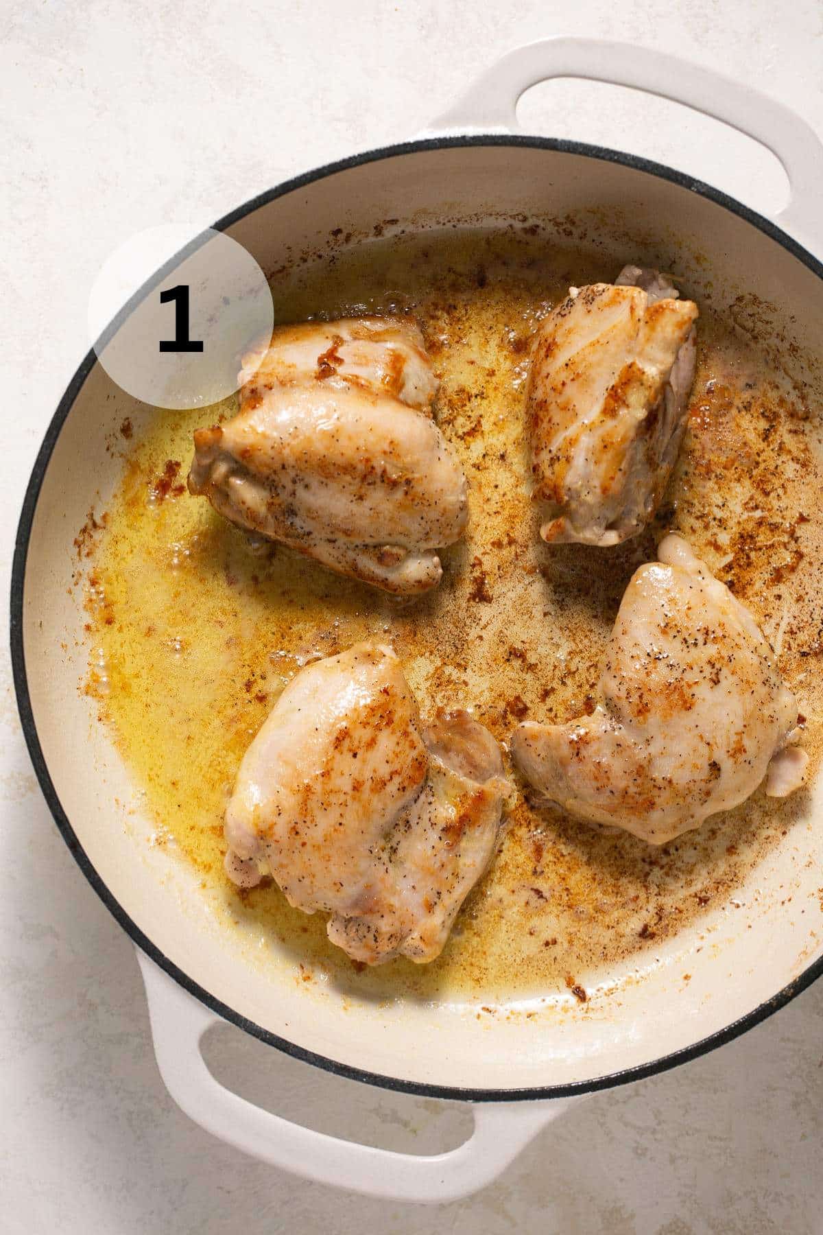 Searing chicken in a large skillet with butter.