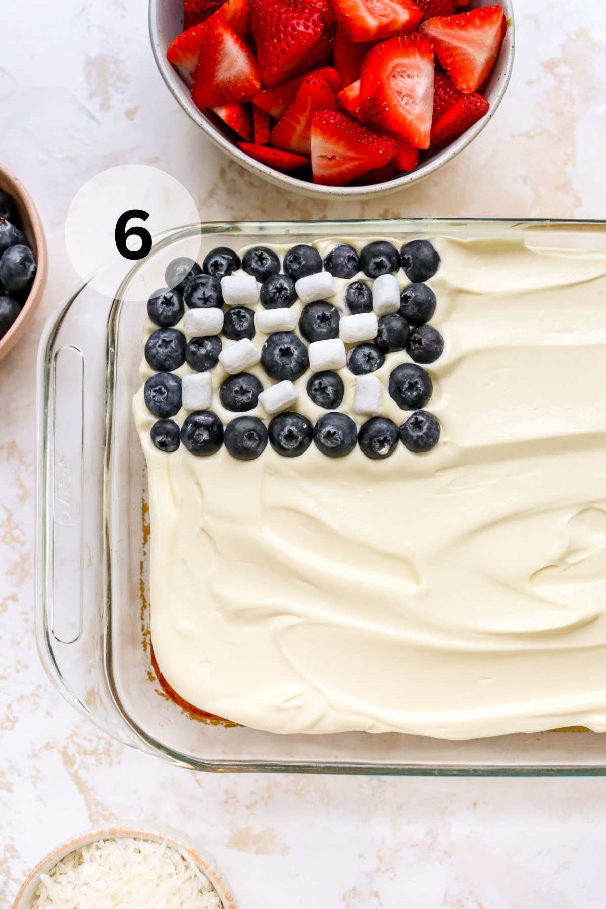 Adding blueberries and mini marshmallows in the corner of the cake.