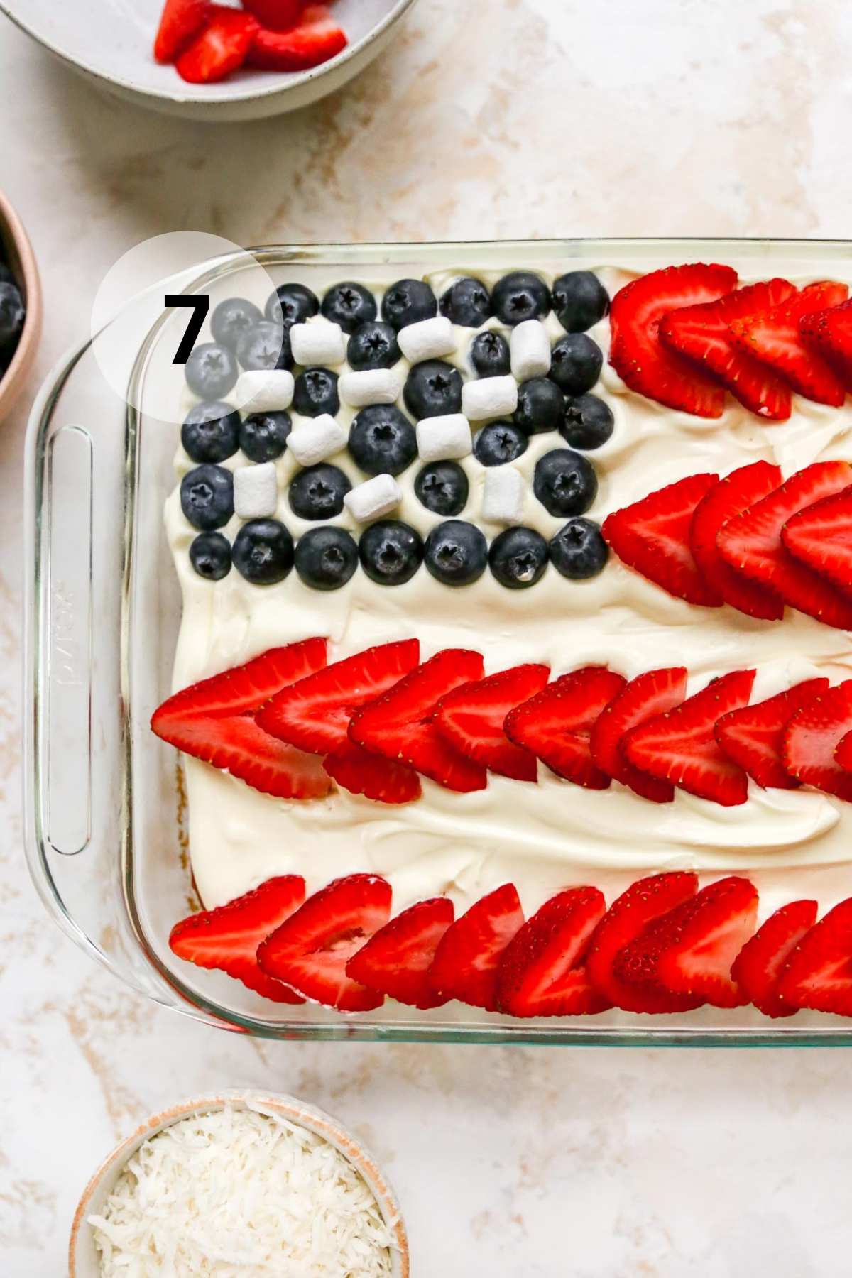 Adding overlapping strawberries for the red lines on a flag cake.