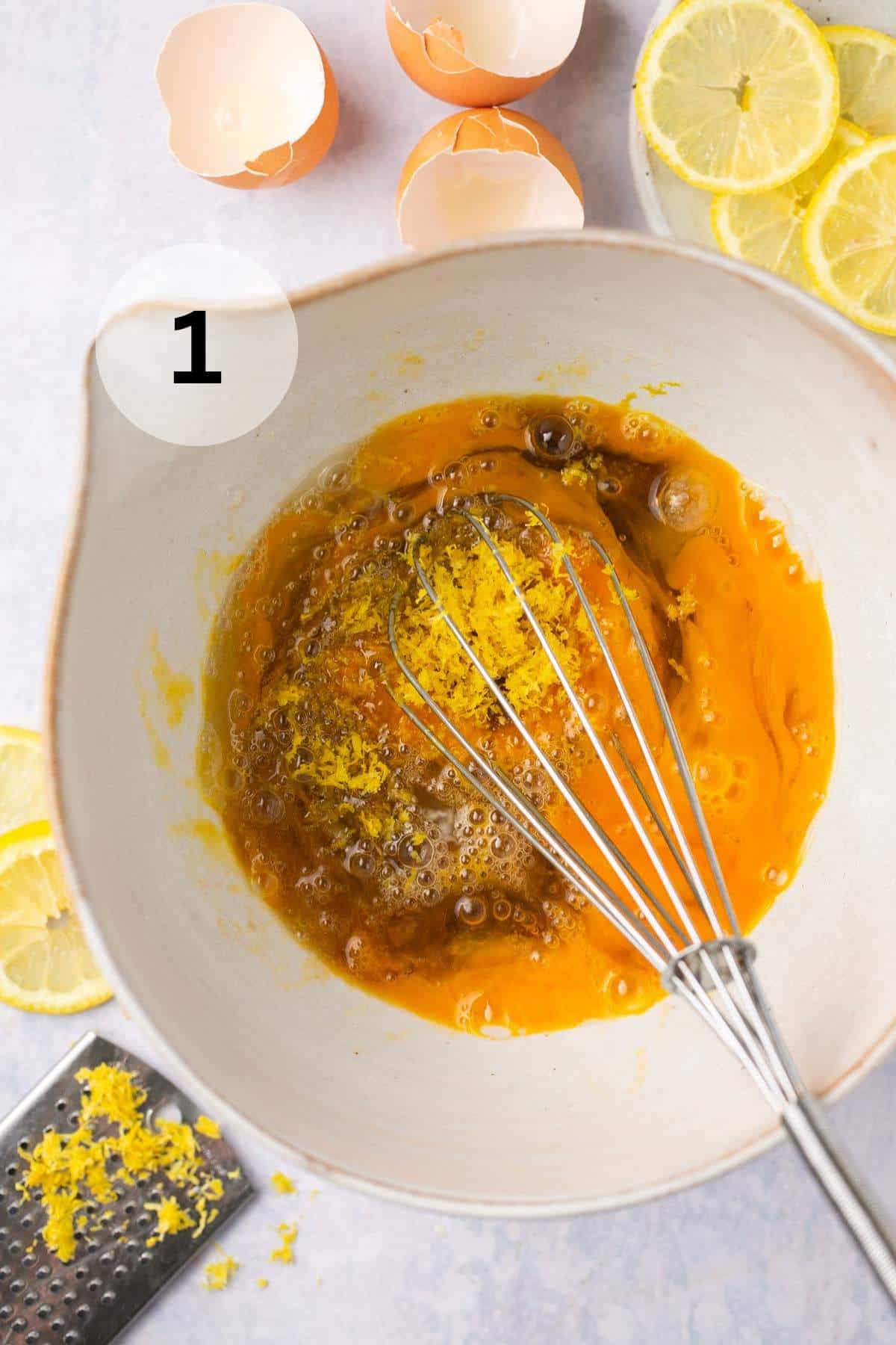 Whisking eggs with sugars and lemon zest.