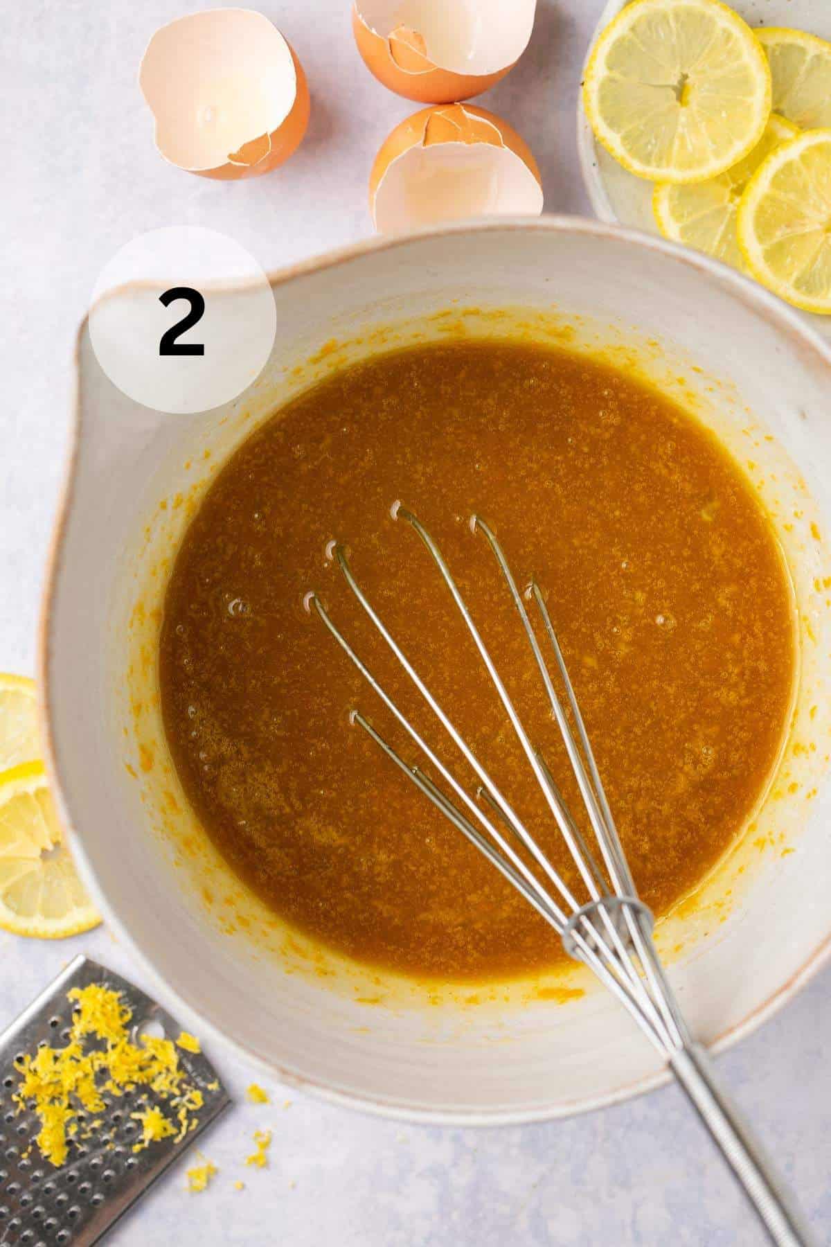 Whisking olive oil with brown sugar and eggs in a large bowl.