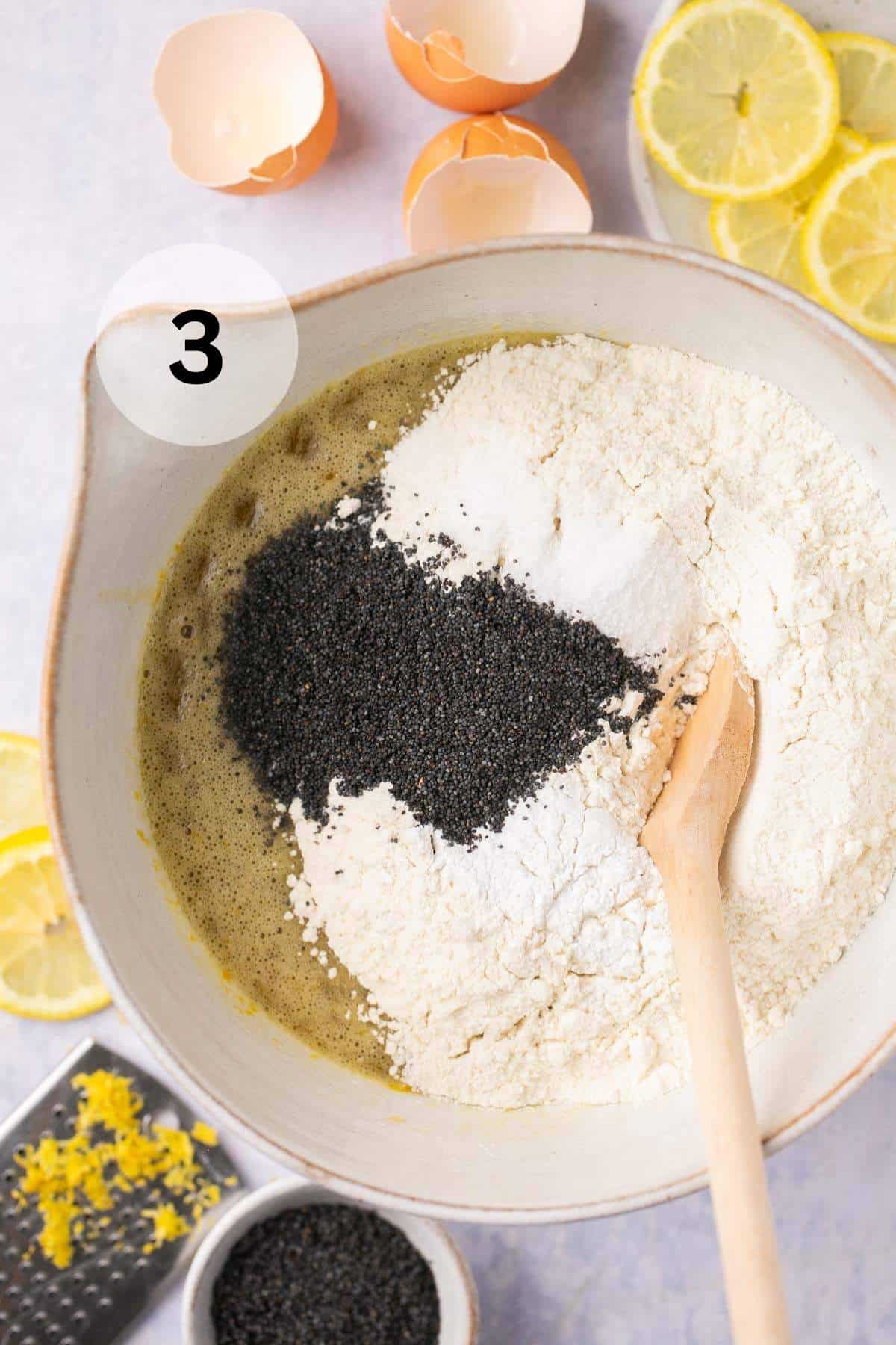 Adding flour and poppy seeds to wet ingredients in a large bowl.