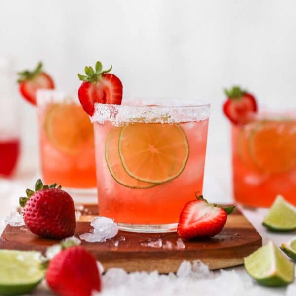 Strawberry margarita garnished with lime slices and fresh strawberries.