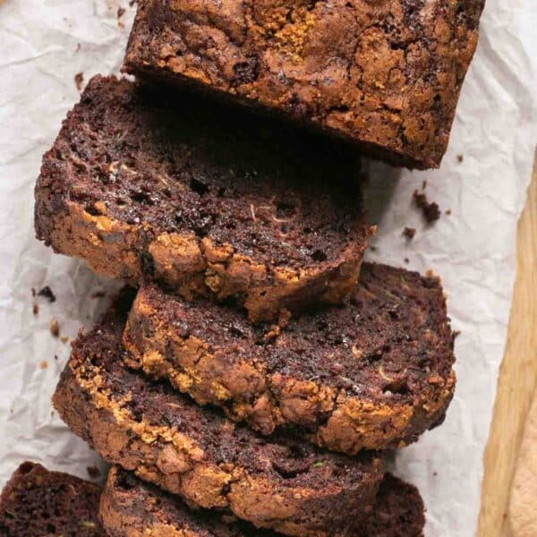 Sliced chocolate zucchini bread on parchment paper.