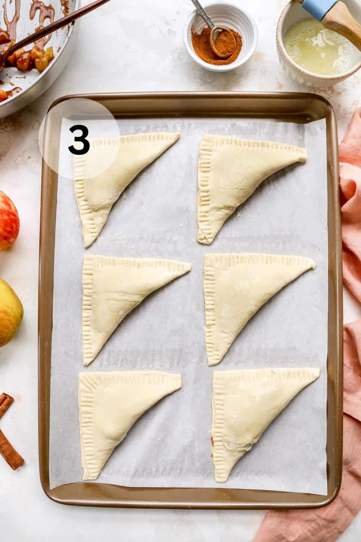 Folded over puff pastry dough on a baking sheet.