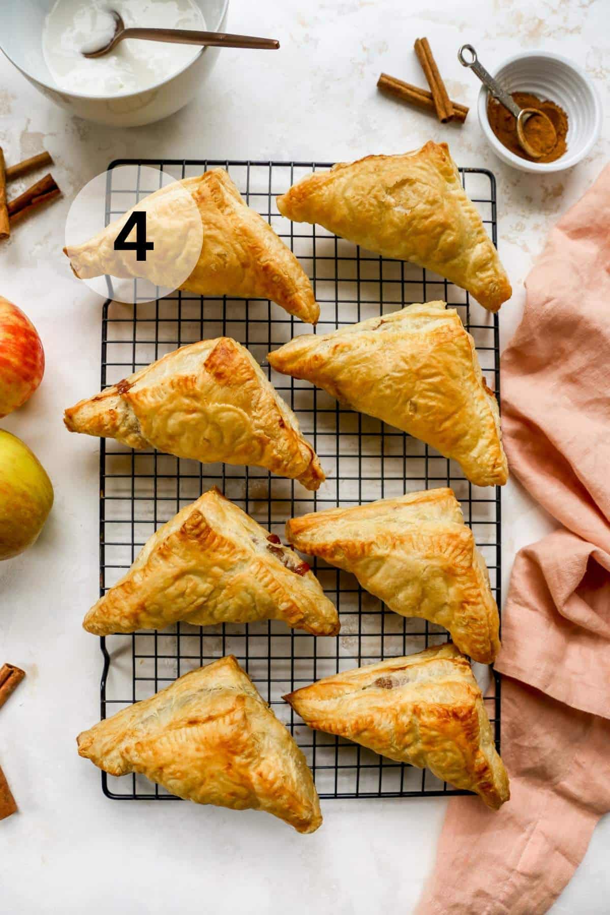 Baked apple turnovers on a wire rack.