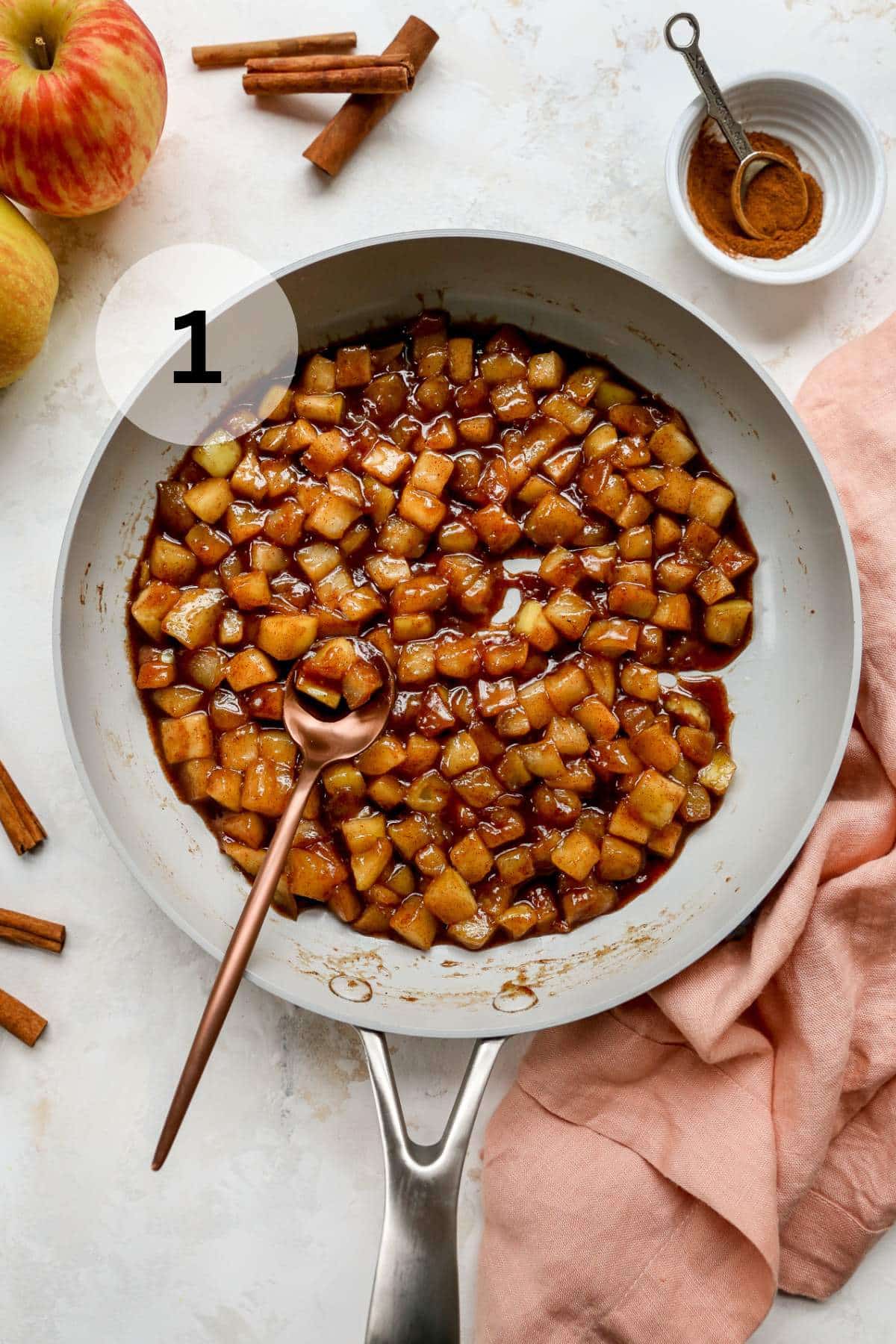 Cooking diced apple in a large pan.
