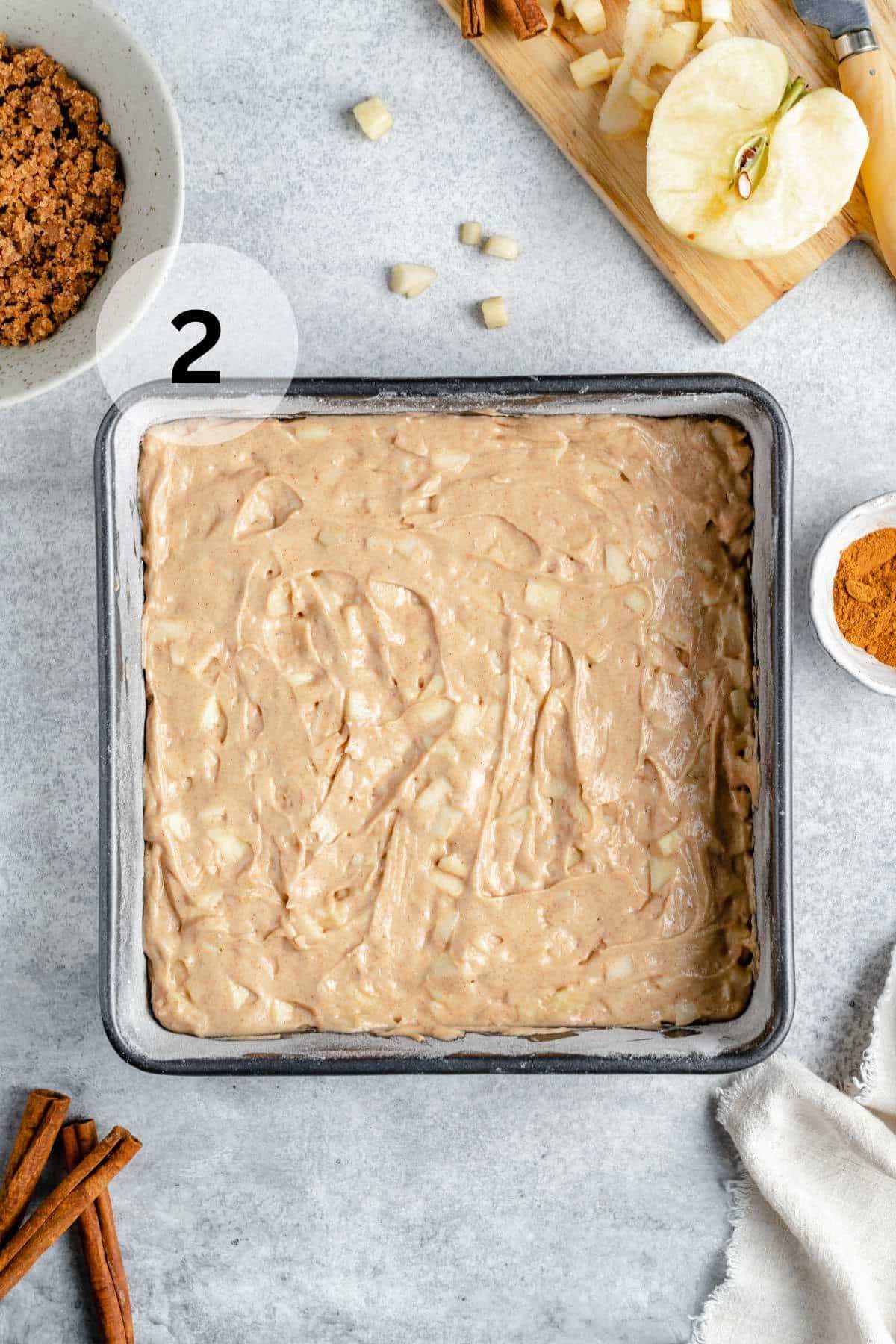 Apple coffee cake batter in a square baking pan.