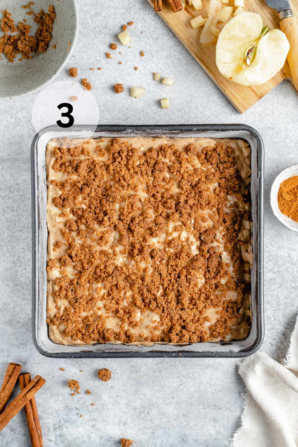 Streusel sprinkled over the top of an apple cake.