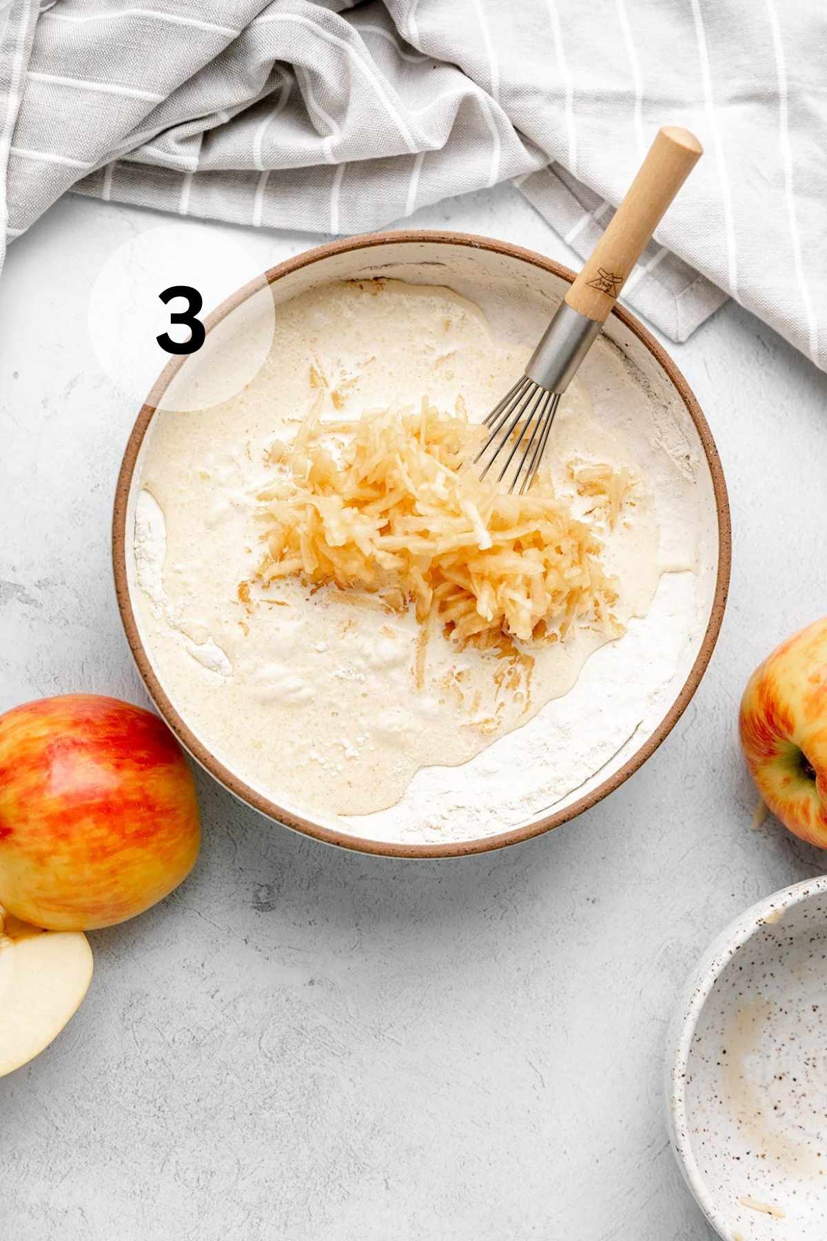 Whisking shredded apples into pancake batter.