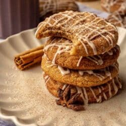 Chai cookies drizzled with icing and stacked on a plate.