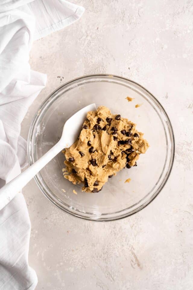 Folding chocolate chips into cookie dough.