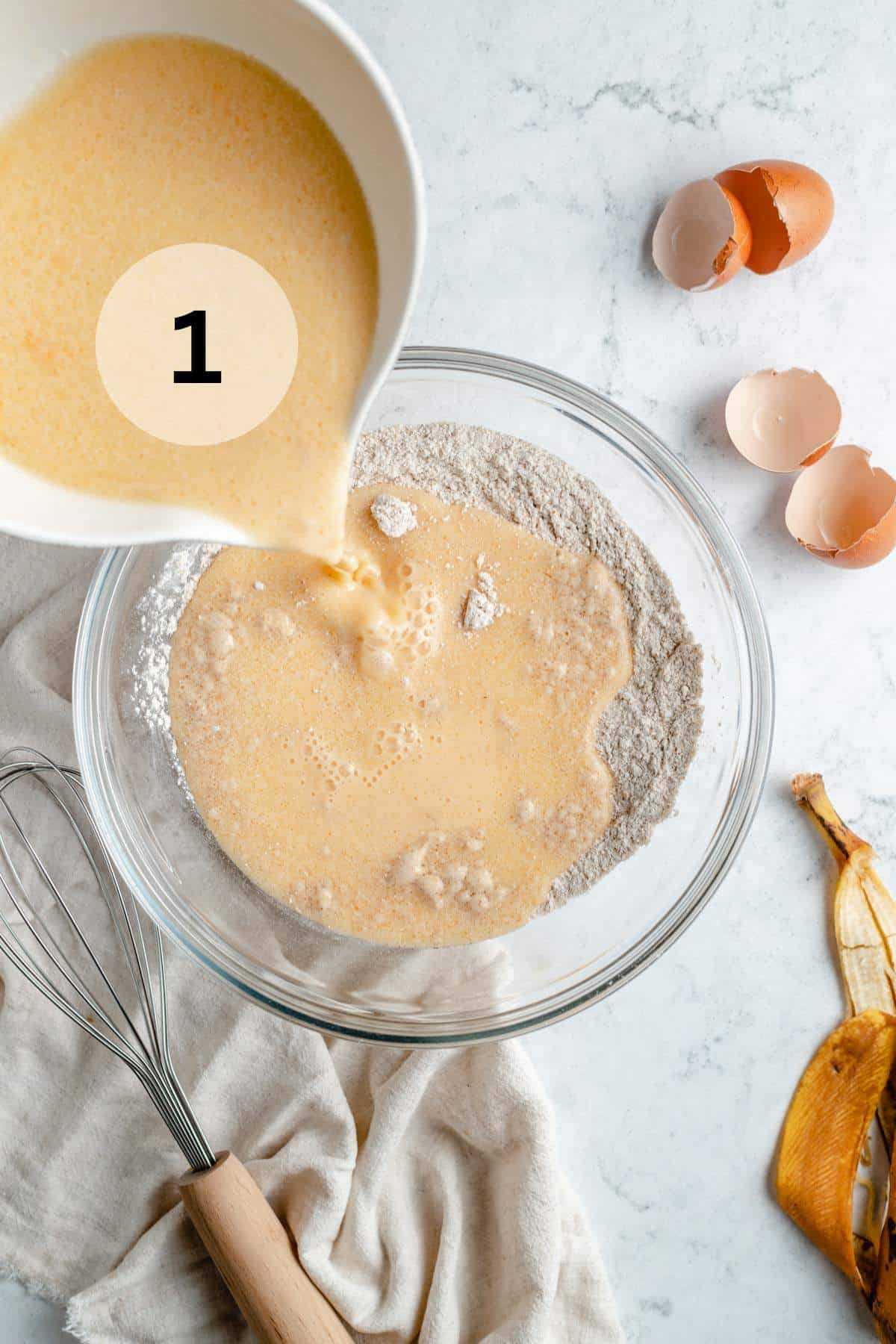 Pouring wet ingredients into a bowl with the dry ingredients.