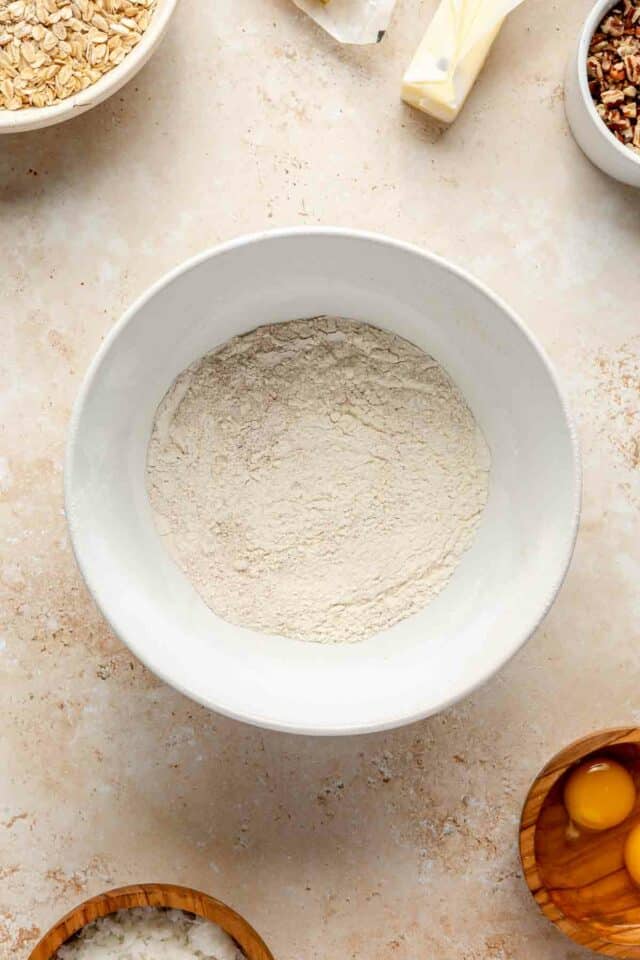 Flour mixed with cinnamon, baking powder and salt in a white bowl.