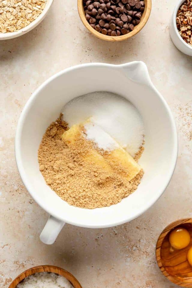 Adding butter and sugars to a large bowl.
