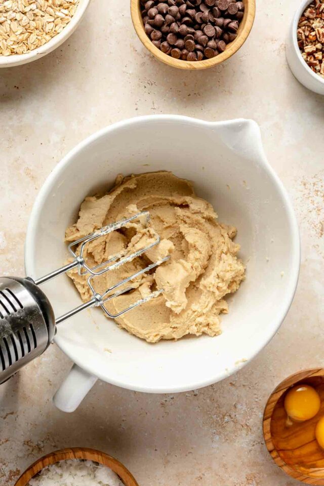 Using an electric mixer to beat butter with sugar.