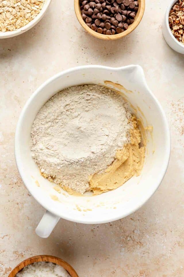 Adding flour to butter mixture in a large bowl.