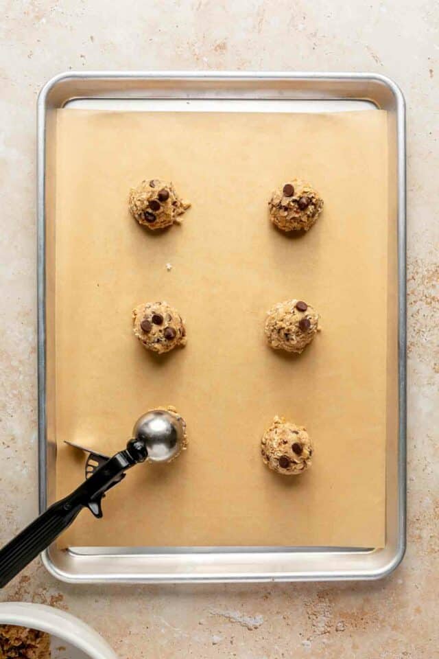 Scooping dough balls and placing on a cookie sheet.