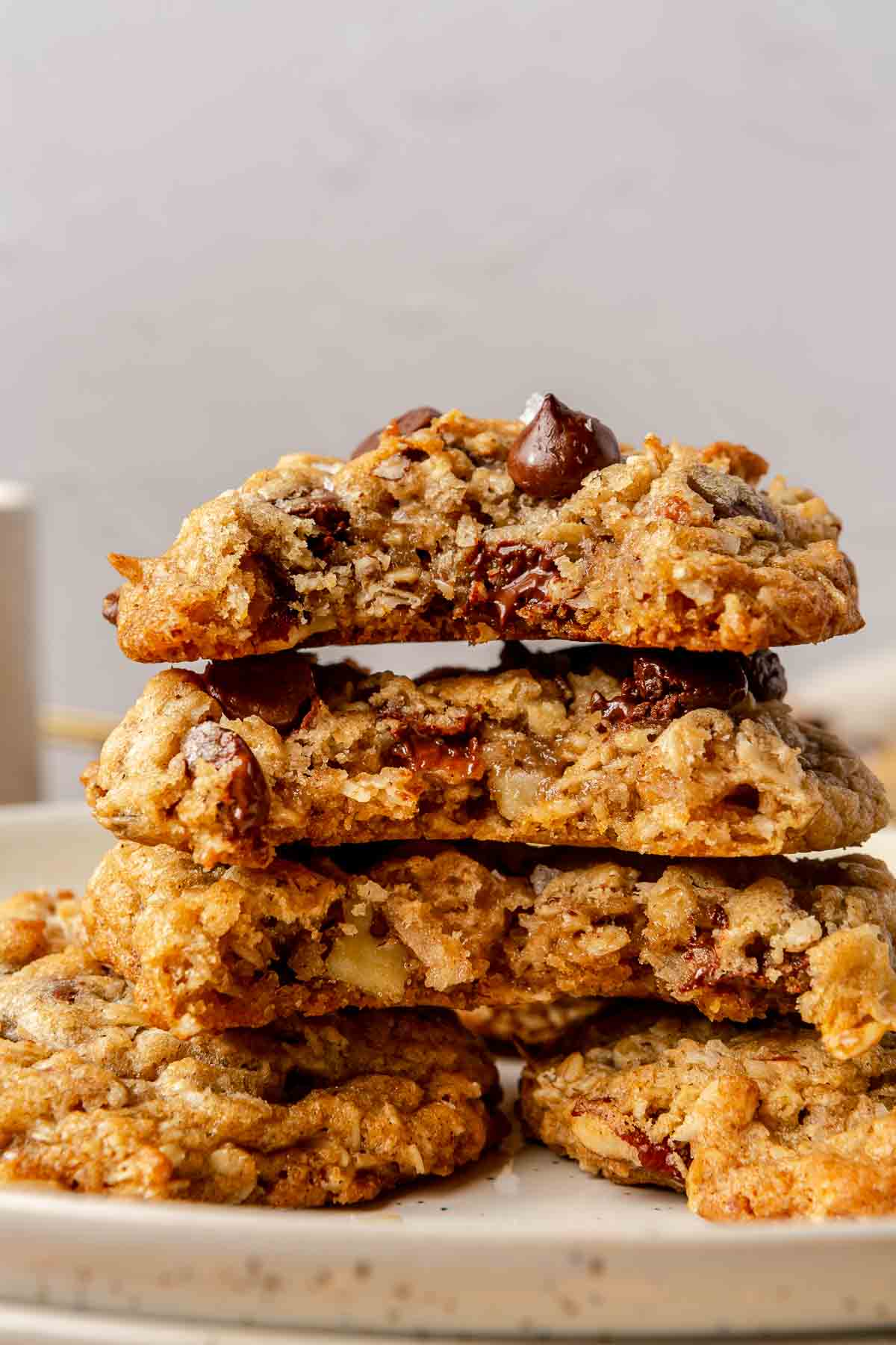 Oatmeal chocolate chip cookies stacked on a plate.