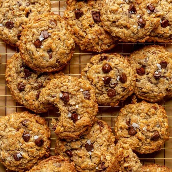 Cowboy cookies stacked on a wire rack.