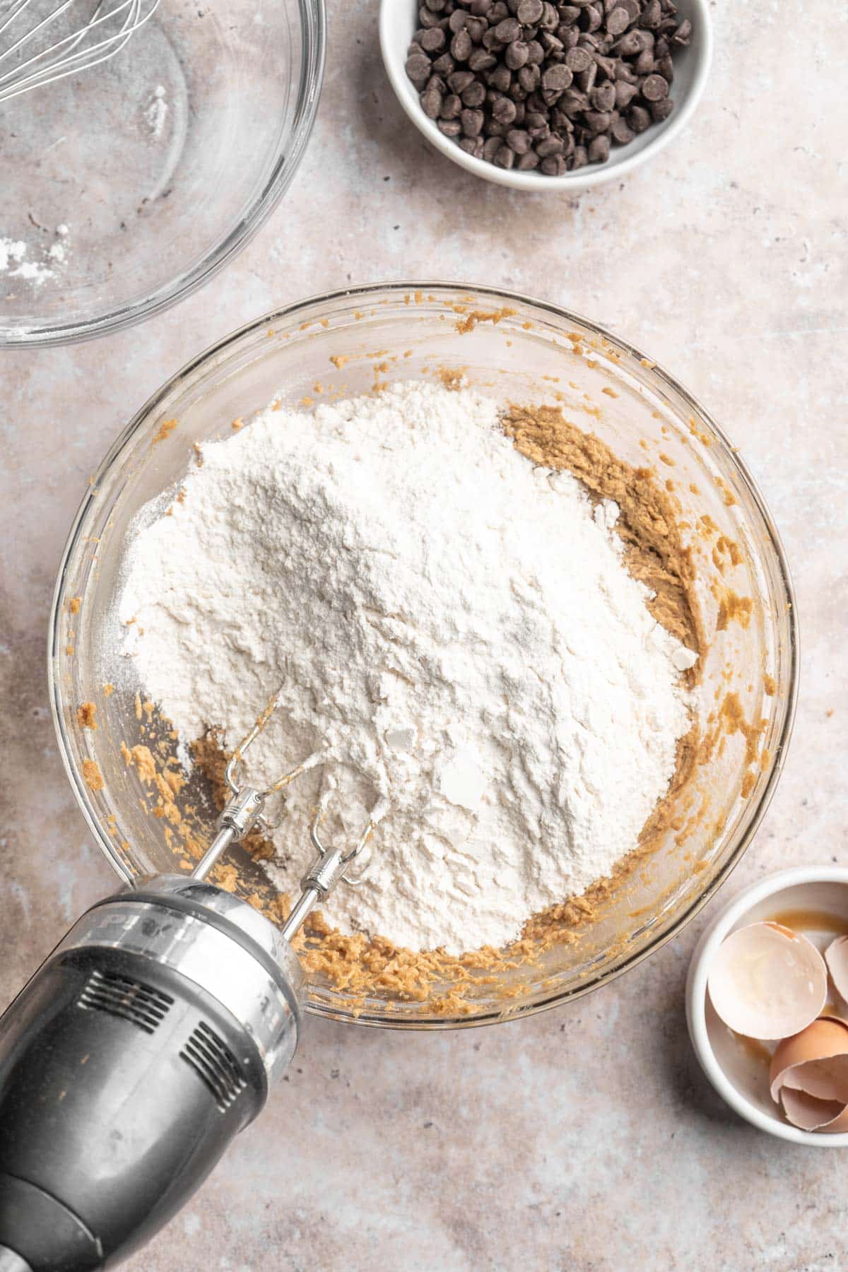 Mixing flour with butter and sugar mixture in a large bowl.