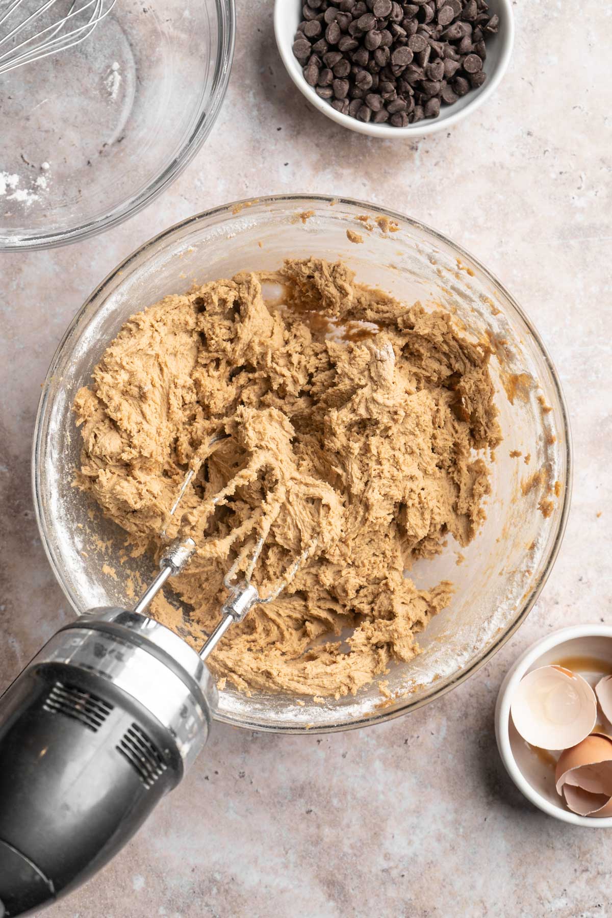 Using a hand mixer to mix cookie dough.