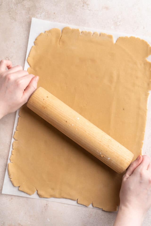 Using a rolling pin to roll cookie dough into a rectangle.