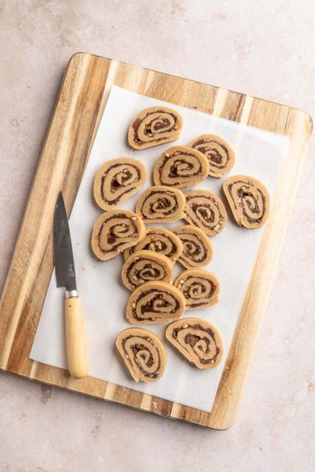 Slices of raw date cookies on parchment paper.