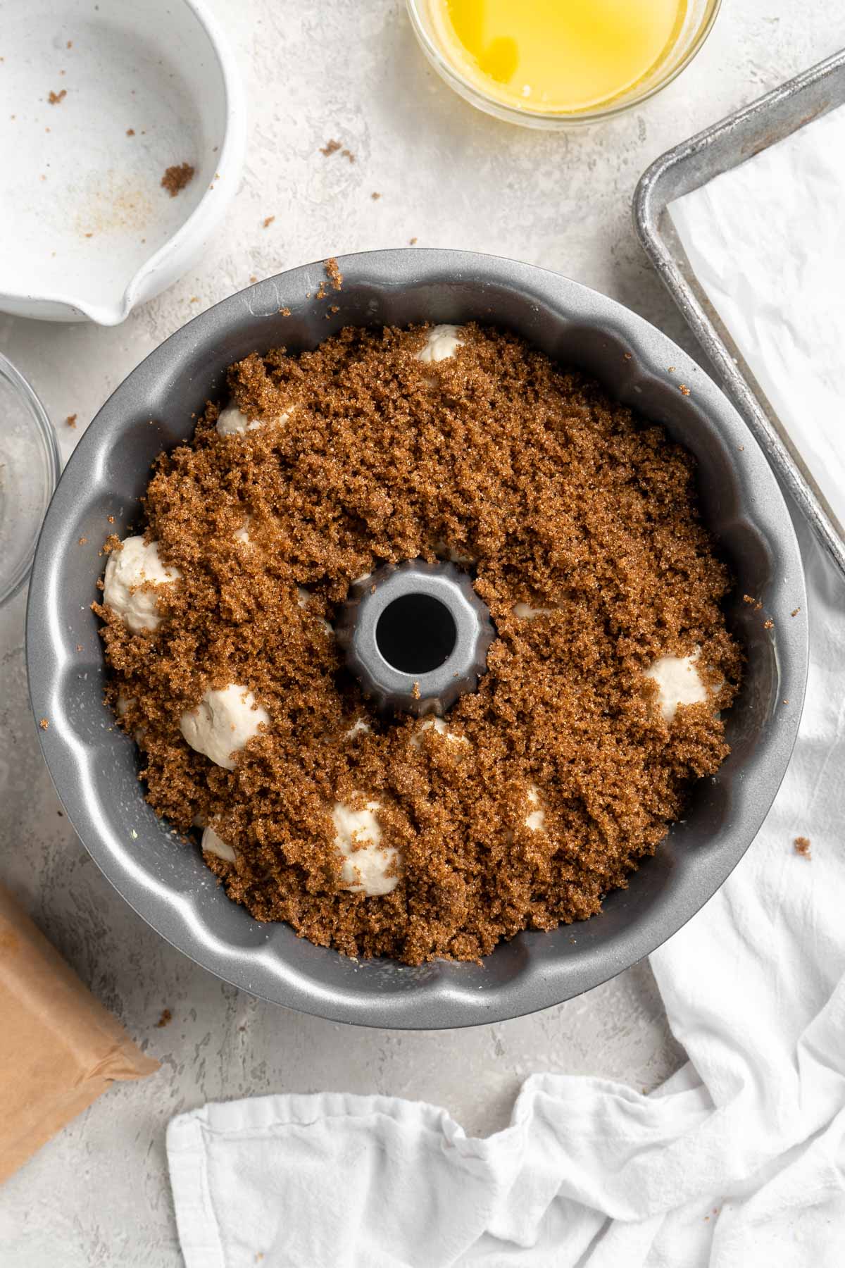 Brown sugar sprinkled over rolls in a bundt pan.