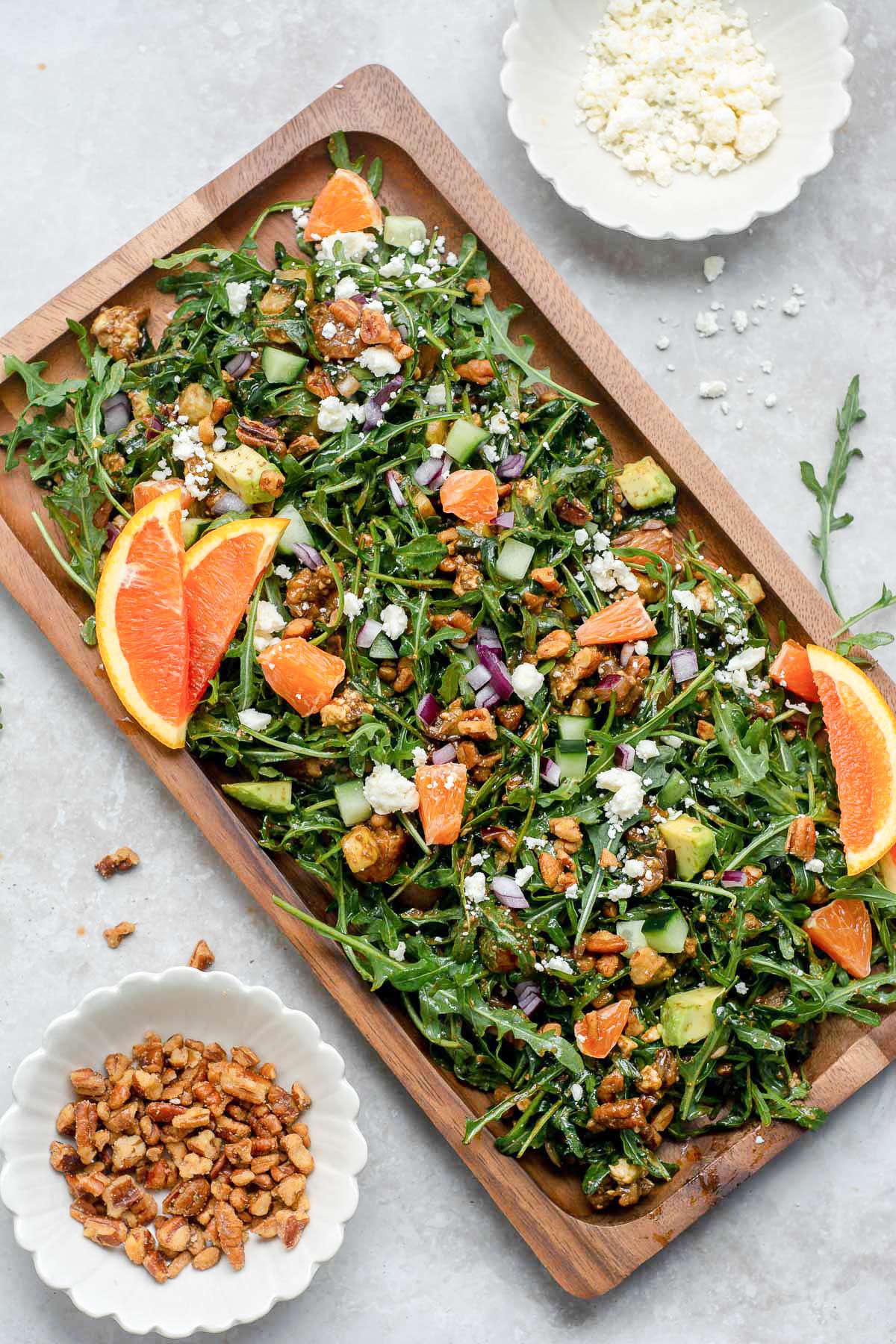 Arugula salad topped with toasted pecans, feta cheese, sliced oranges and avocado.
