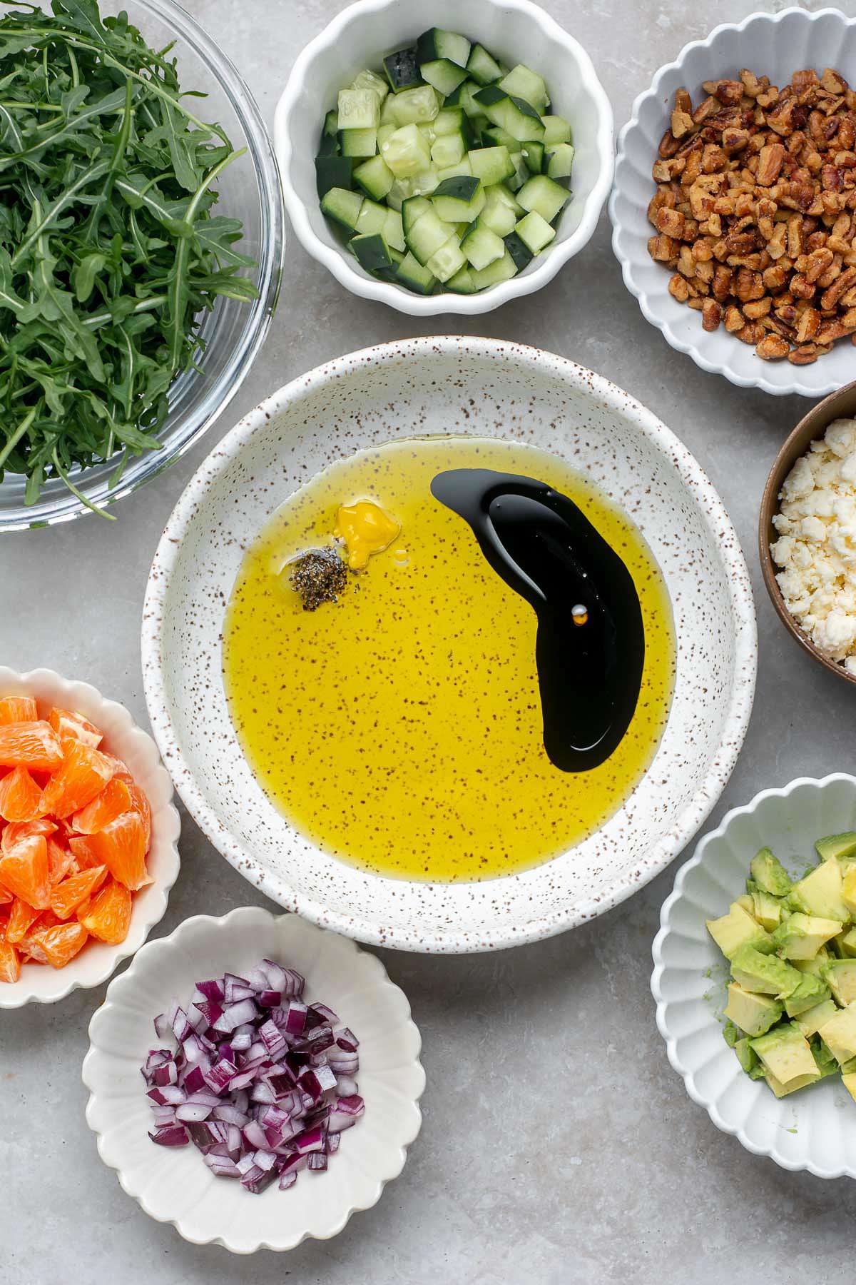 Olive oil in a bowl with balsamic vinegar, mustard, salt and pepper.