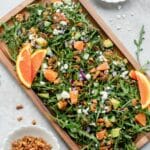 Arugula salad topped with orange, pecans, and feta cheese.