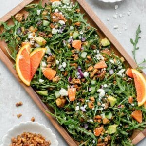 Arugula salad topped with orange, pecans, and feta cheese.