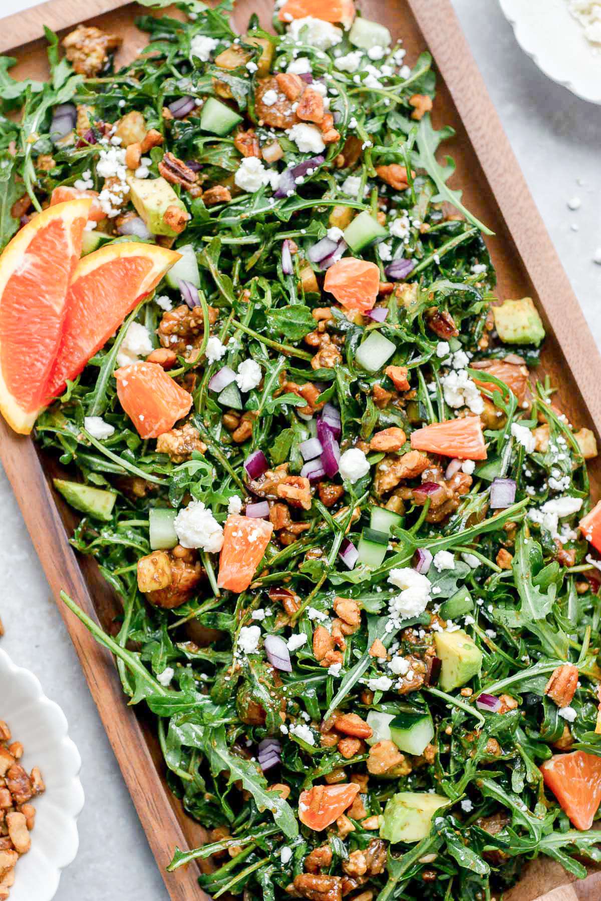 Arugula salad topped with orange, pecans, and feta cheese.