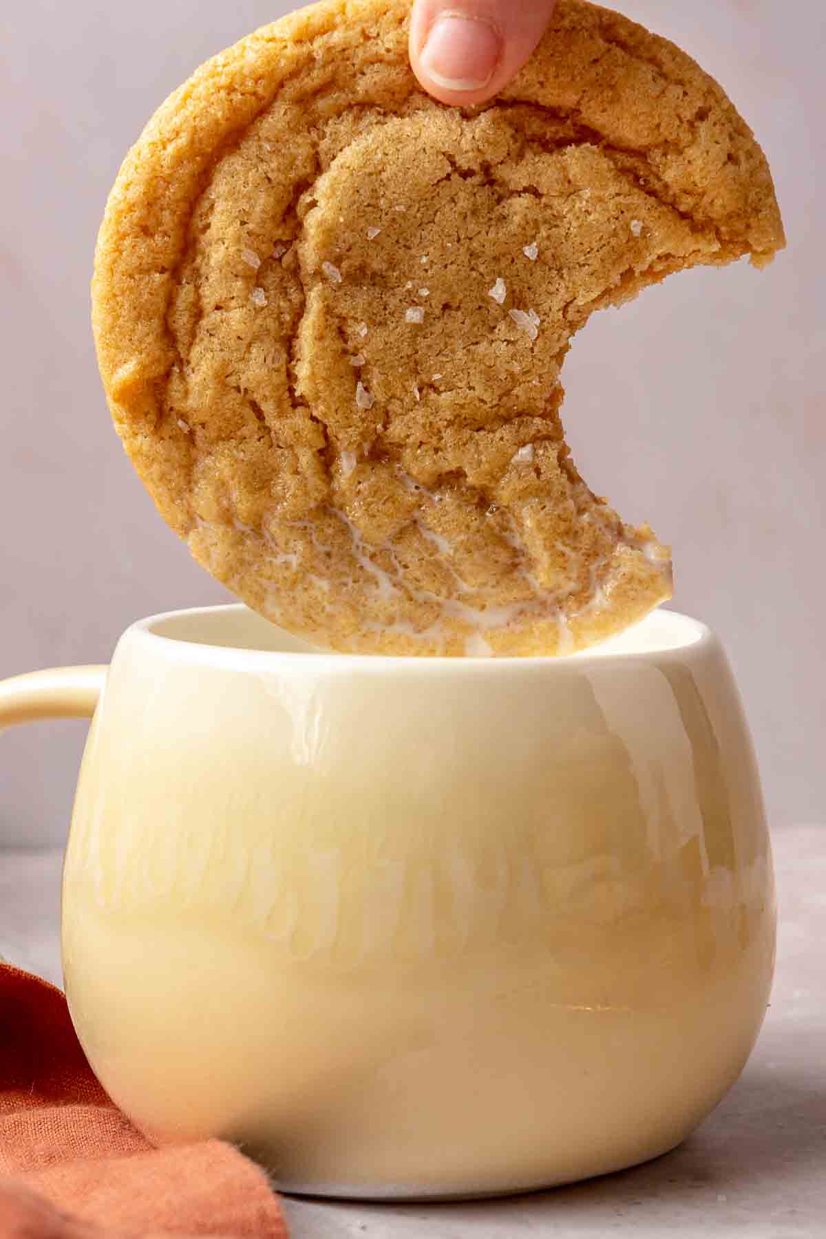 Dipping a cookie into a mug of milk.