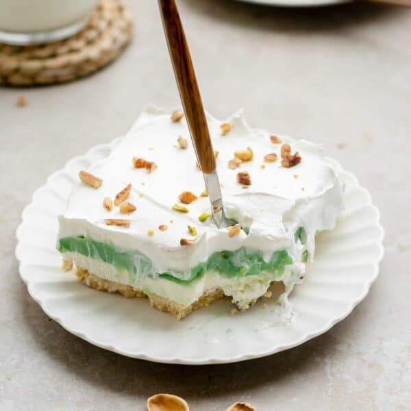 Slice of pistachio dessert with a fork in it.