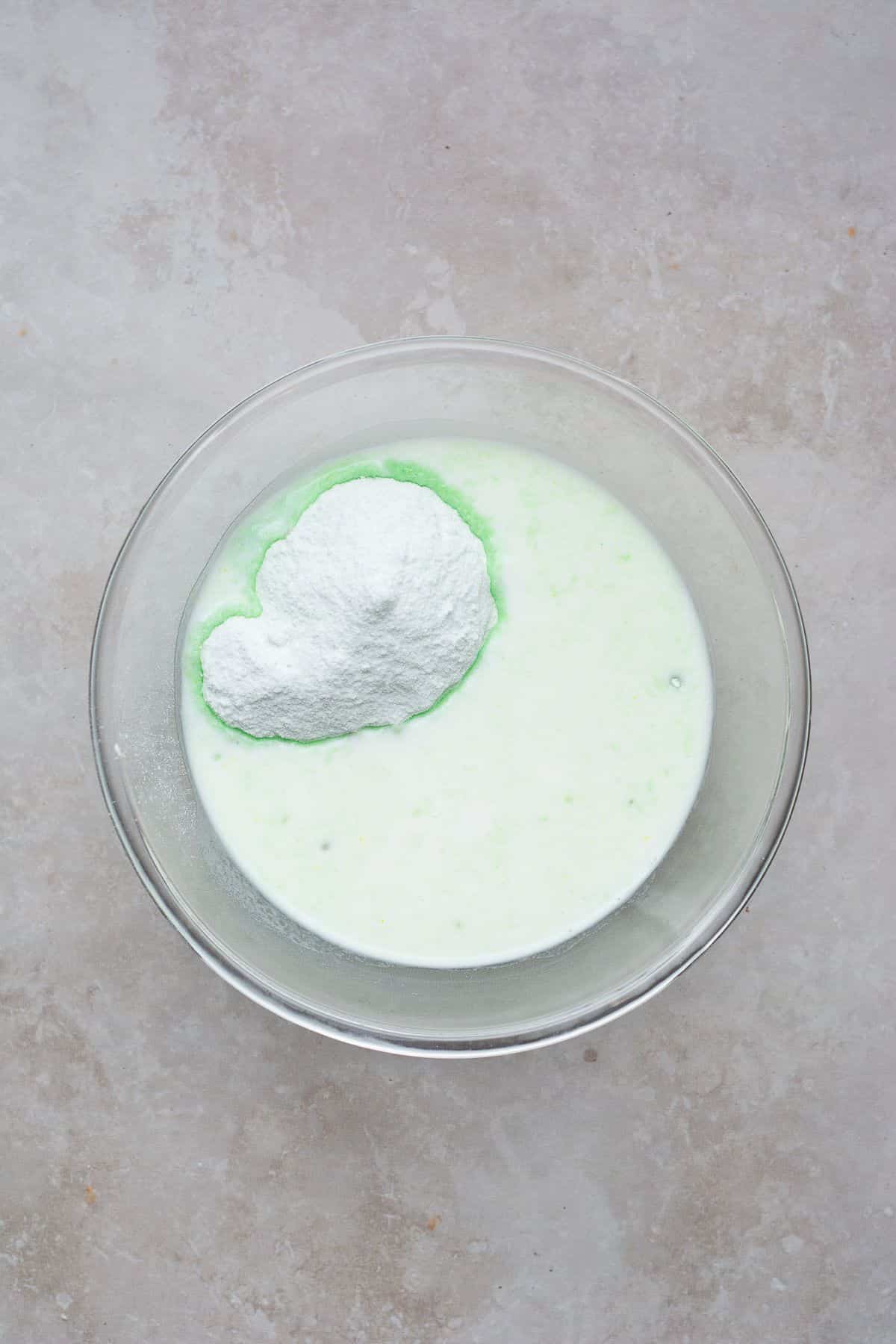 Mixing milk and pistachio pudding in a bowl.