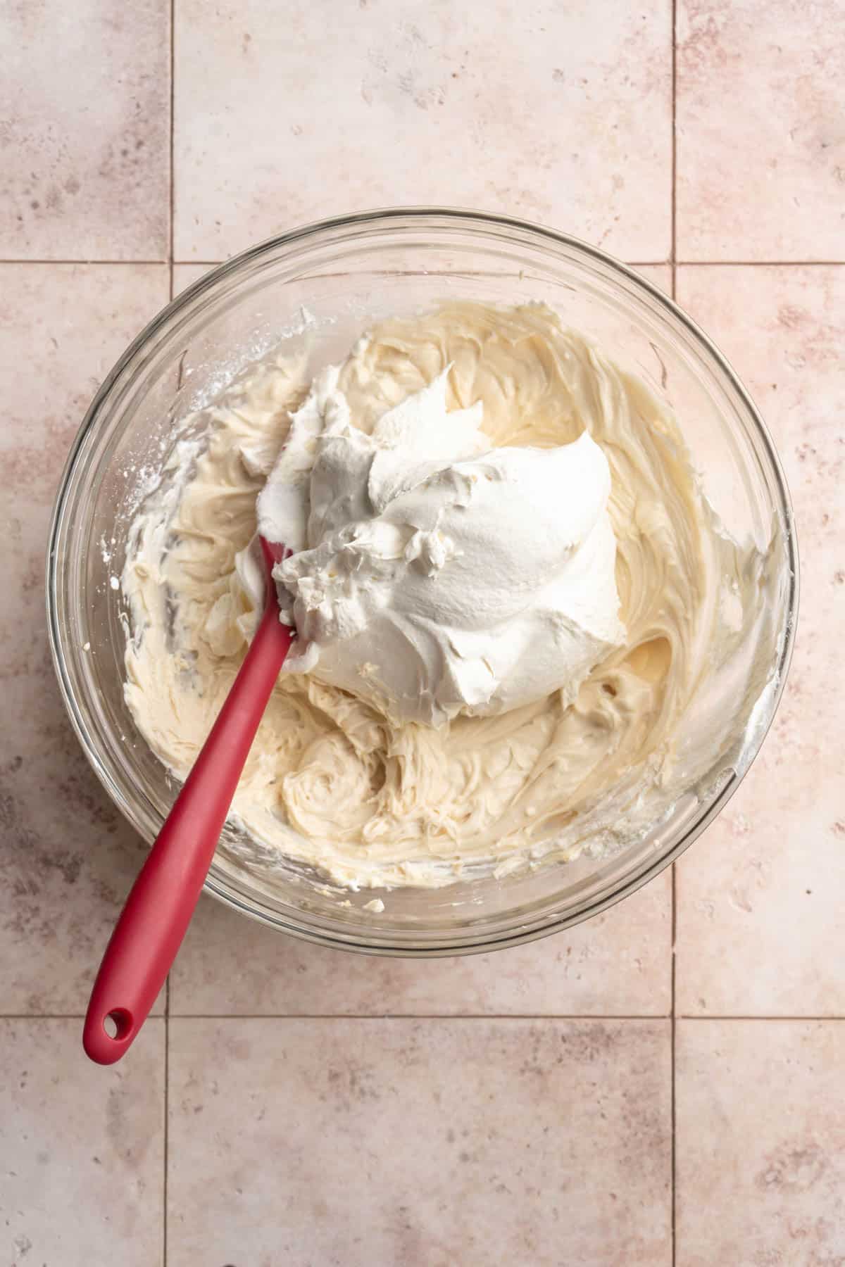Folding Cool Whip into cream cheese mixture.