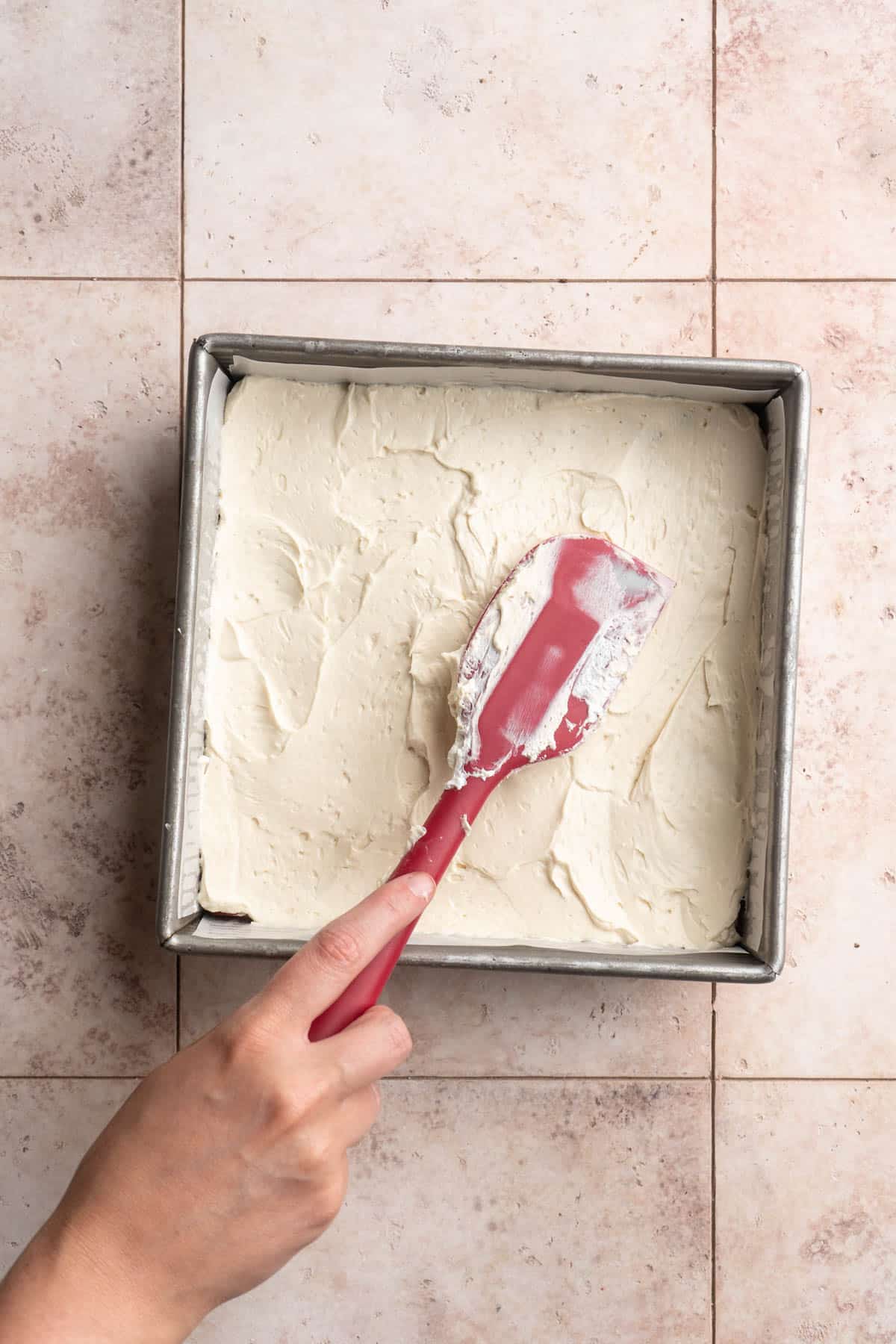 Spreading cream cheese mixture in a pan.