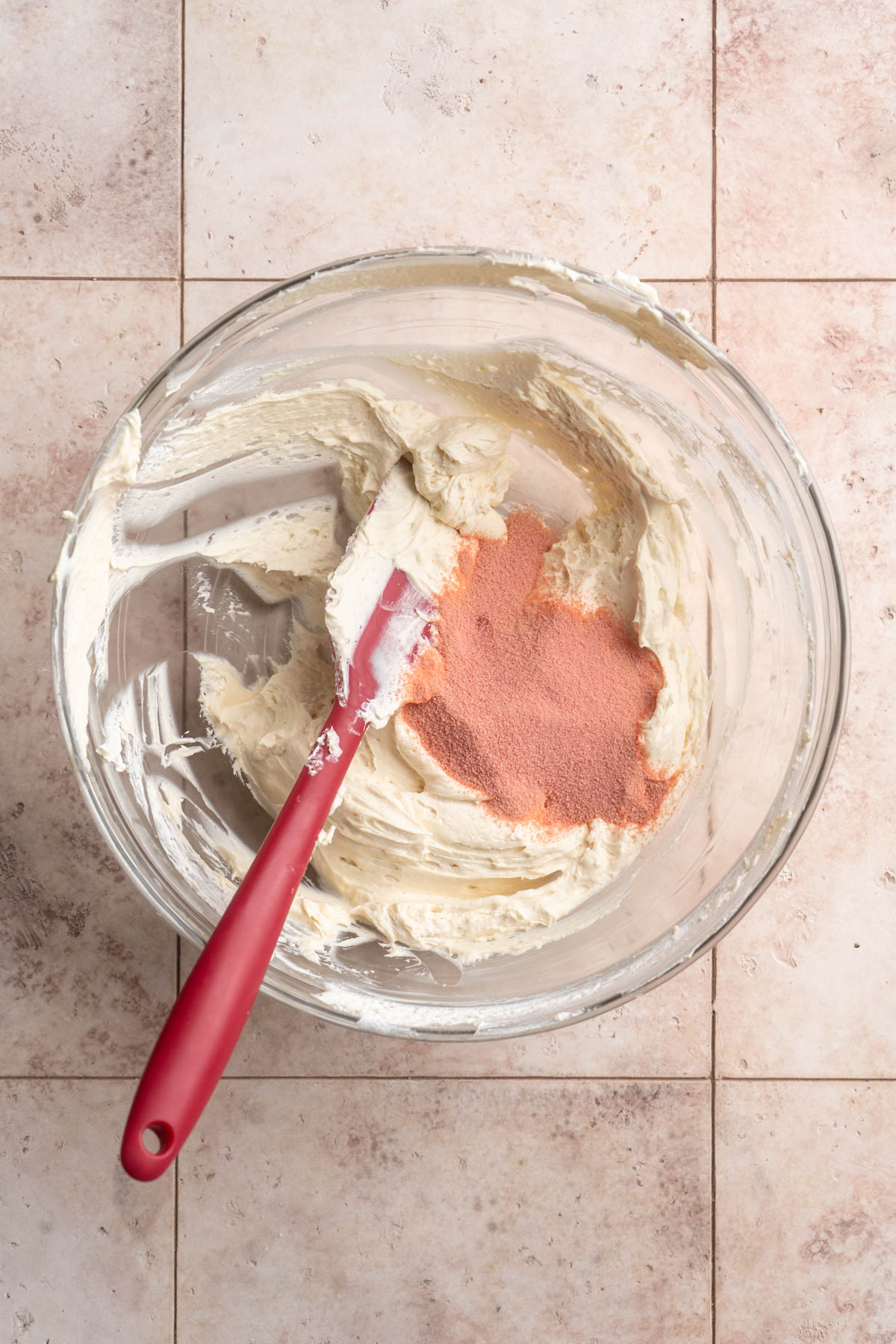 Stirring powdered jello mix into cream cheese mixture.