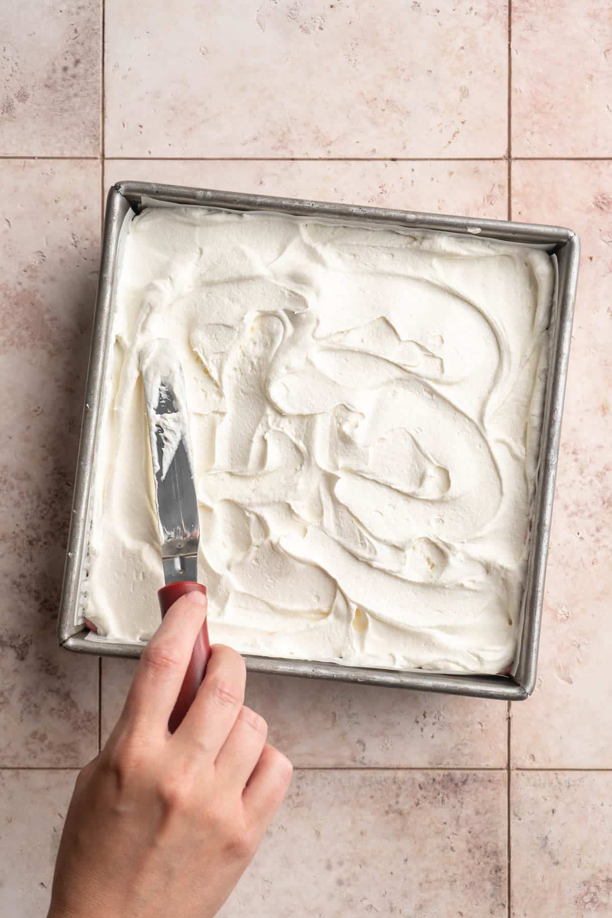 Spreading Cool Whip in a pan.