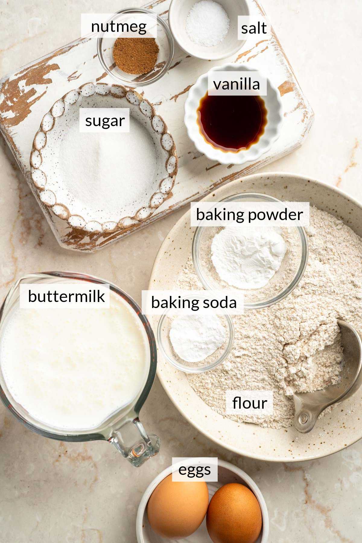 Small bowls with eggs, flour, sugar, buttermilk, vanilla and nutmeg.