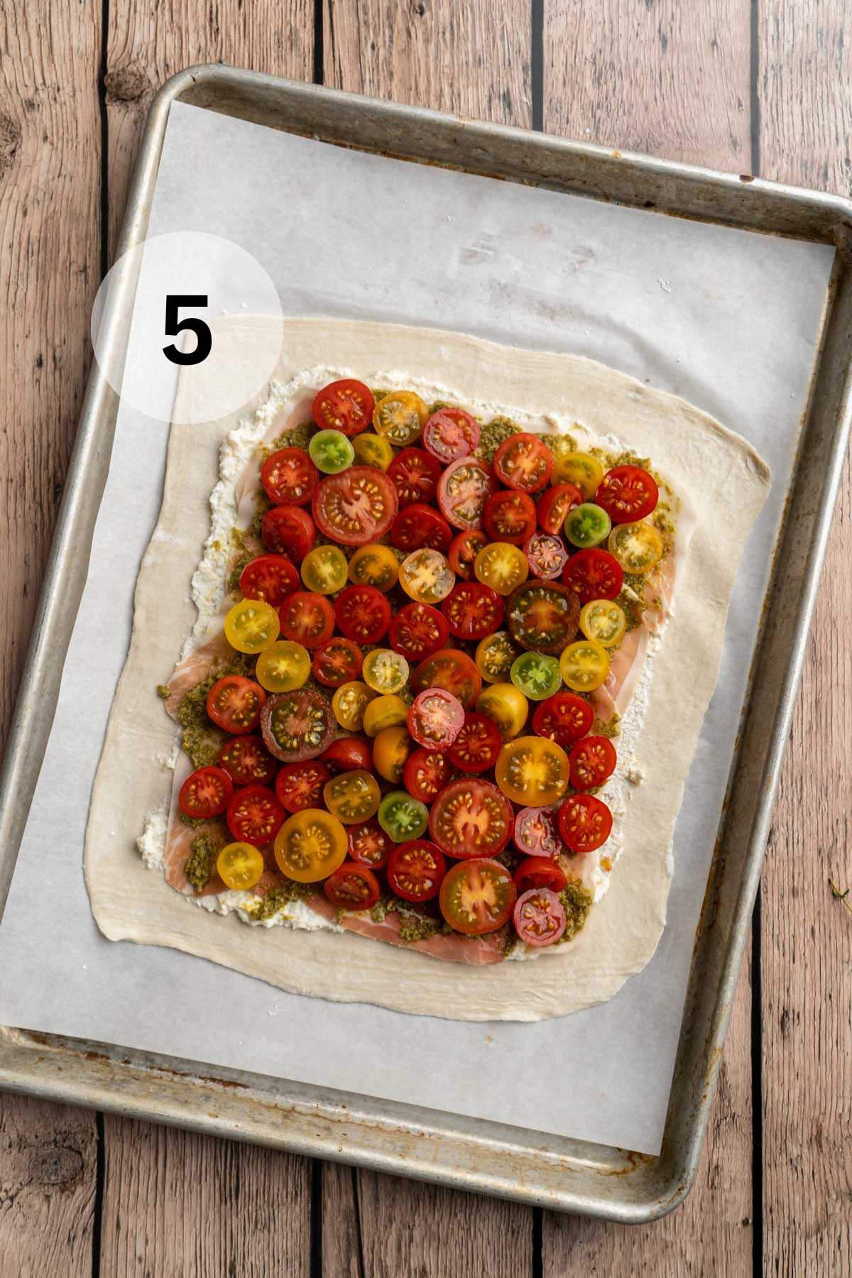 Halved grape tomatoes on top of a puff pastry.