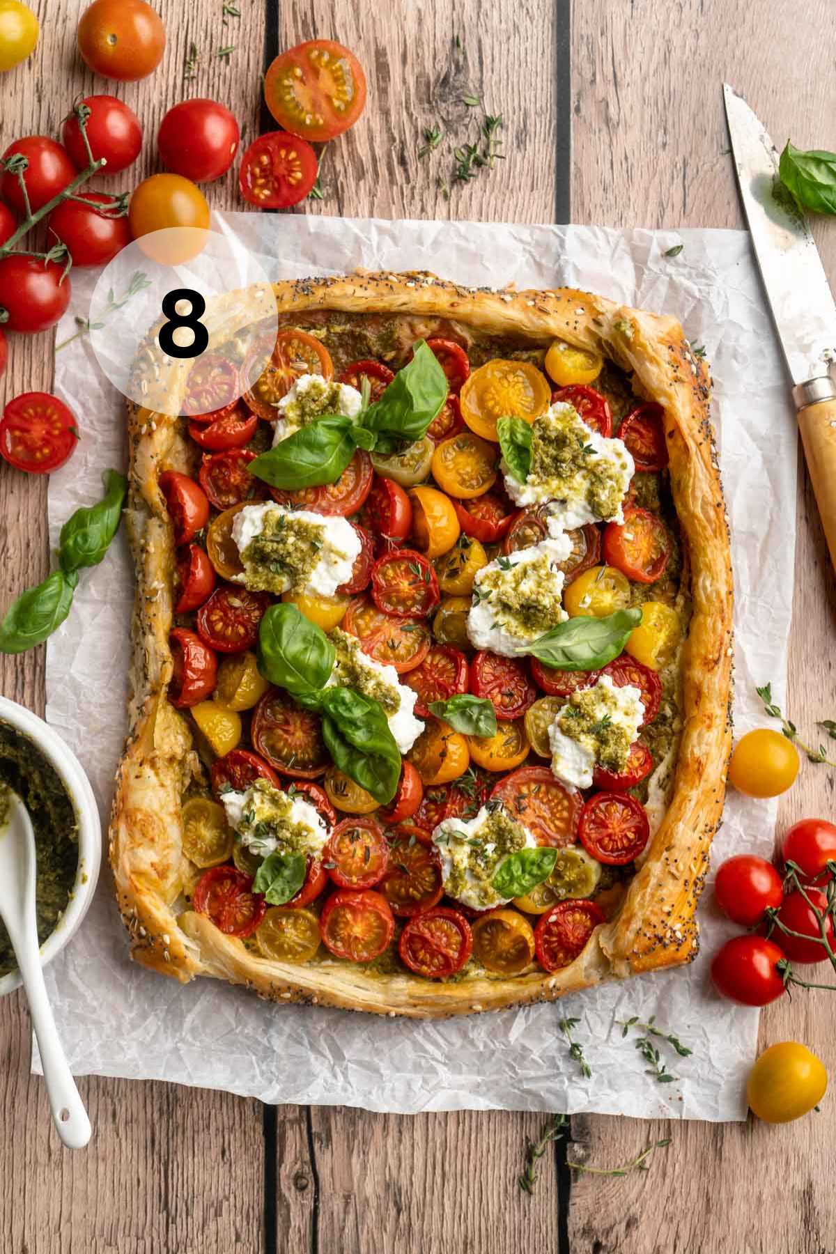 Baked tomato tart garnished with basil leaves.