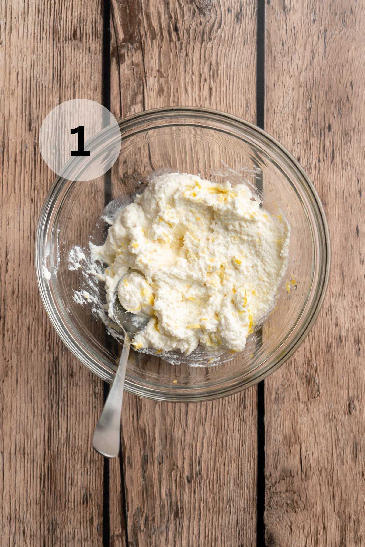 Stirring together ricotta with lemon zest in a small bowl.