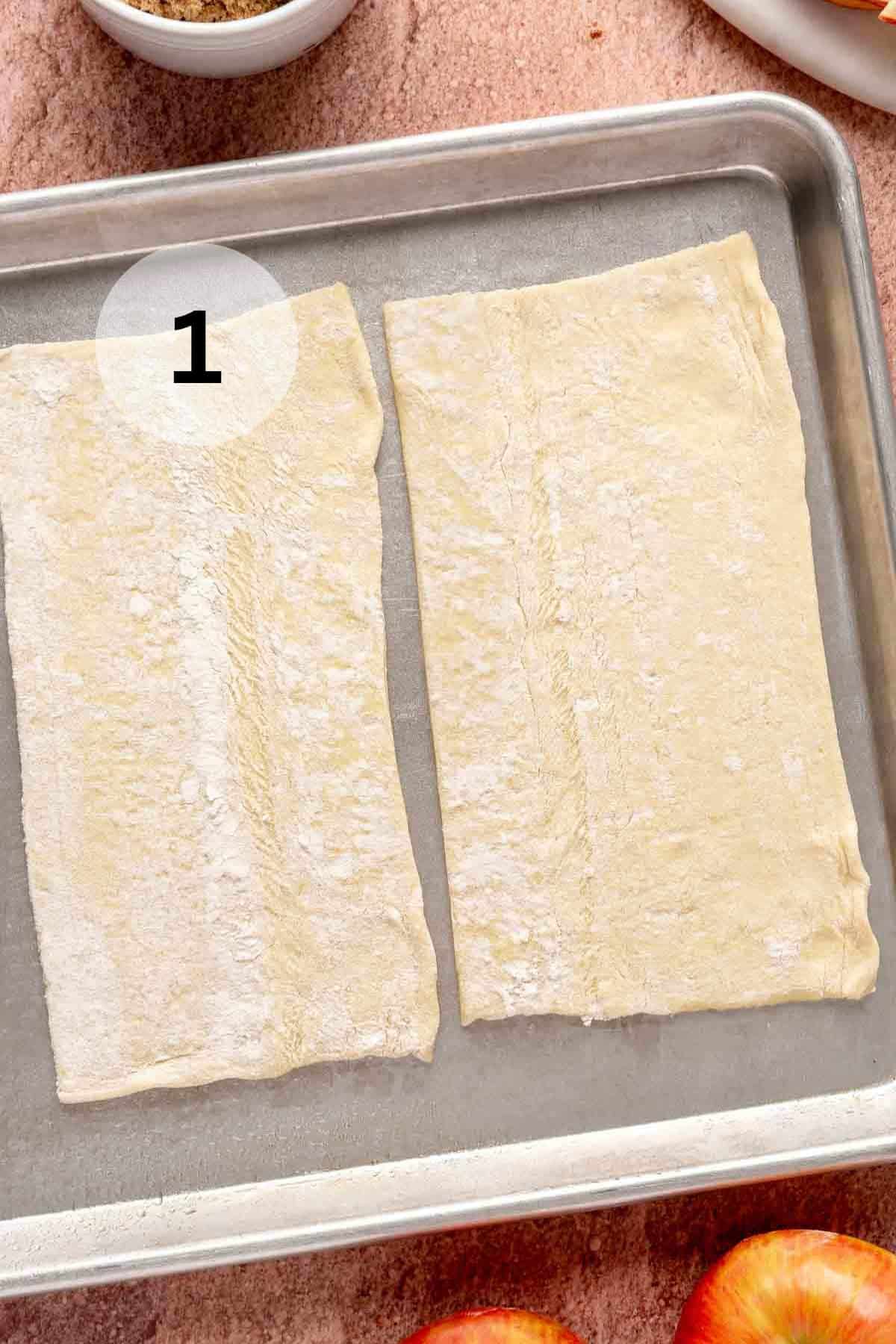 Puff pastry sheet cut in half on a baking sheet.