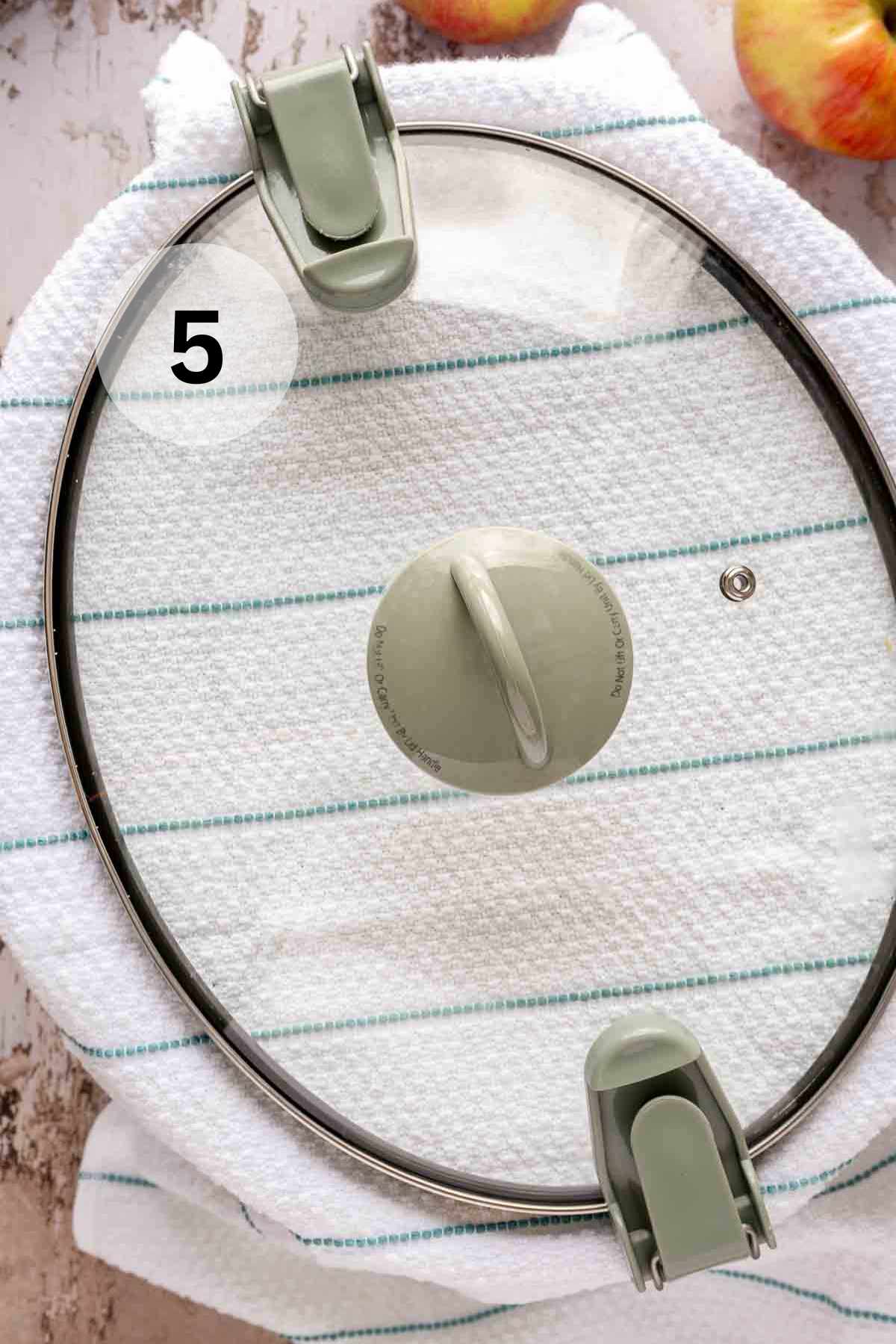 Crockpot lid over dish towel.