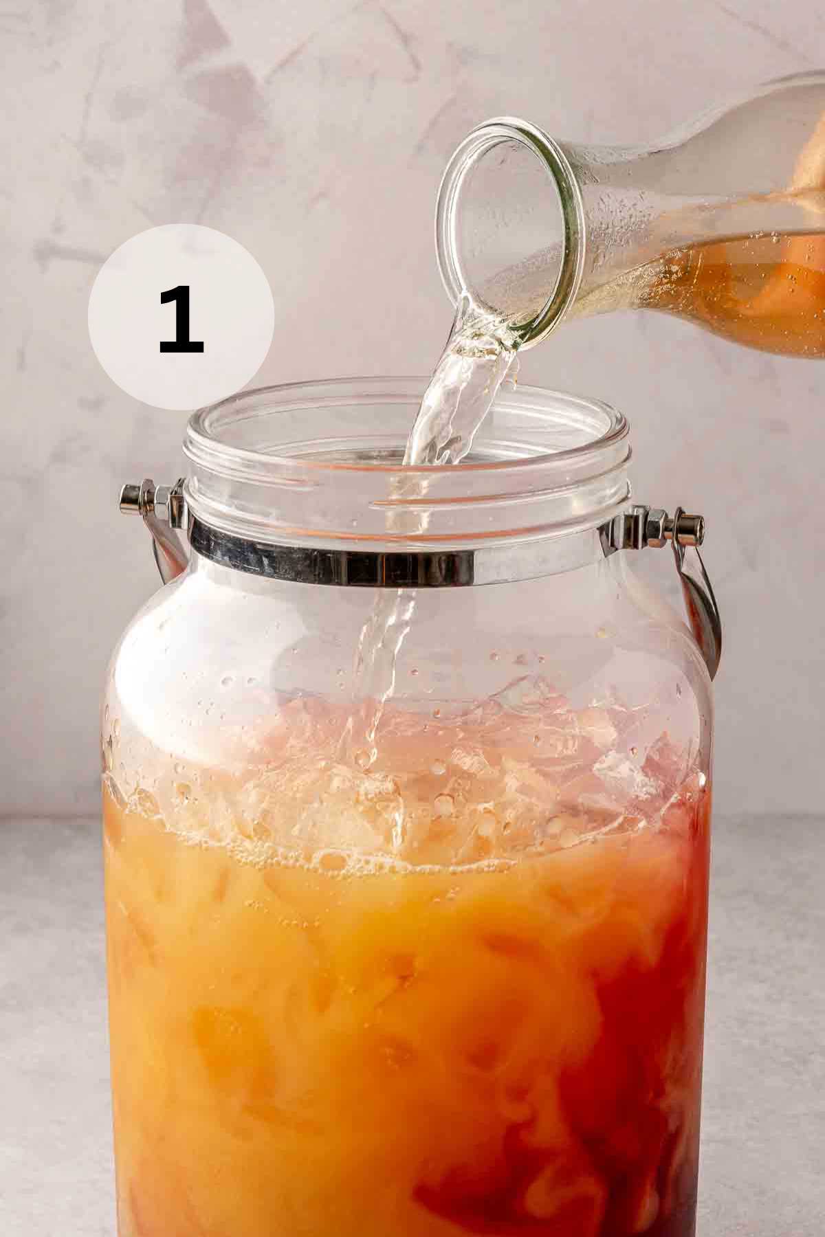 Pouring ginger ale in with cranberry and orange juice.
